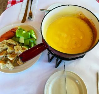 Cheese fondue with bread, sausage and apple