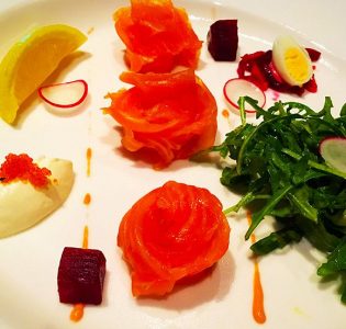 Smoked salmon with apple beetroot salad, quail egg, sour cream and rocket leaves